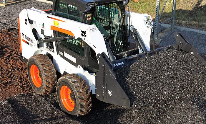 Bobcat S510 beim Verteilen udn Steuen von Kies