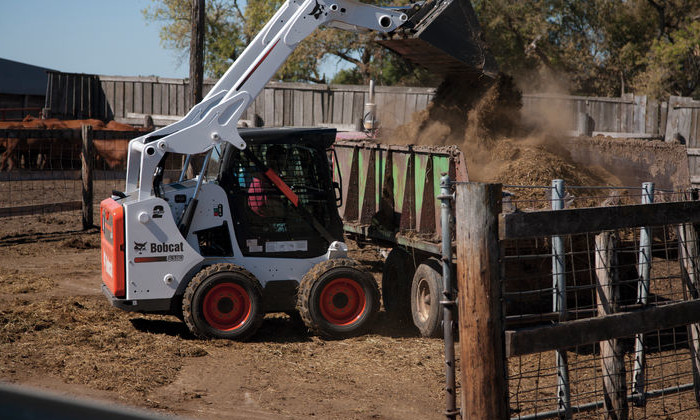 Bobcat S590 beim Verladen von Mist auf dem Bauernhof