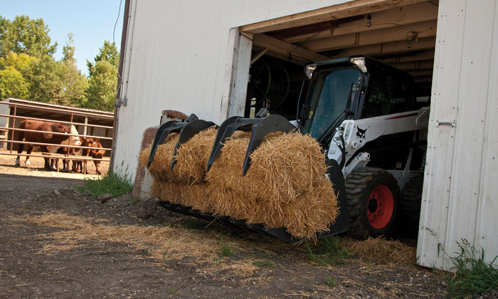 Bobcat S590 mit Strohballen auf dem Bauernhof