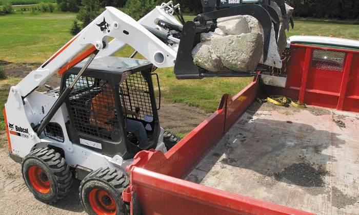 Bobcat S630 beim Verladen von Steinen im Abbruch