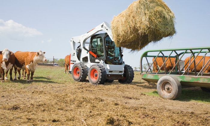 Bobcat S770 mit Ballenforke zum Verladen von Strohballen