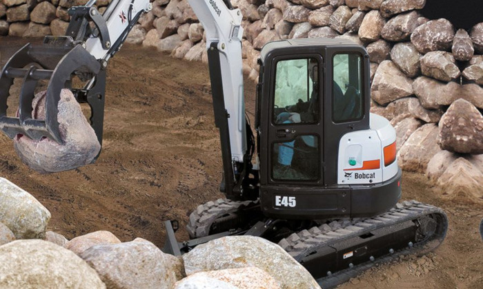 Bobcat E45 auf Kette beim Sortieren von Steinen