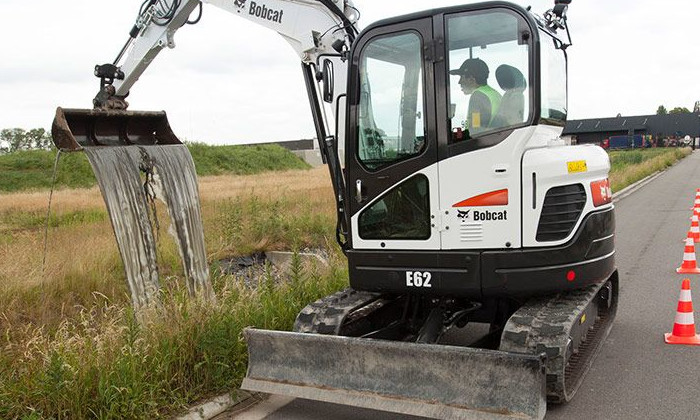 Bobcat E62 mit Grabenräumlöffel bei Arbeiten am Straßenrand