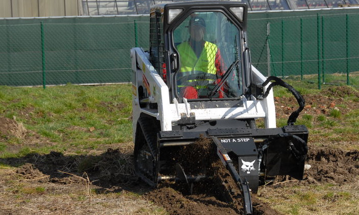 Bobcat T110 mit Grabenfräse bei Arbeiten in der Erde im Tiefbau