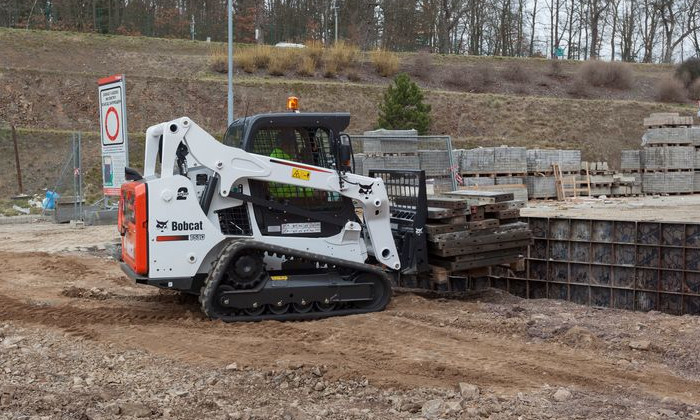 Bobcat T590 mit Gabel zum Verladen von Bohlen