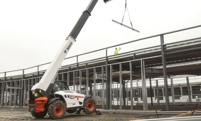 Bobcat T41.140SLP beim Heben von Lasten im Hallenbau