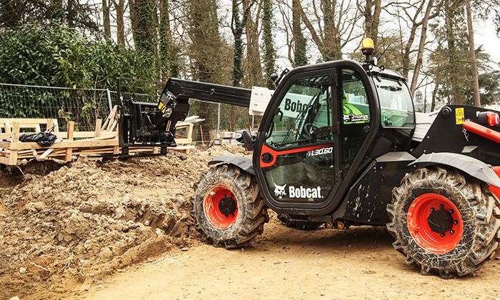 Bobcat TL30.60 beim Verladen von Lasten auf der Baustelle mit der Frontgabel